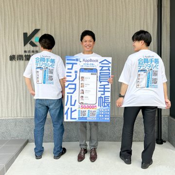 AppBookのTシャツを着て、パネルを持つ３人