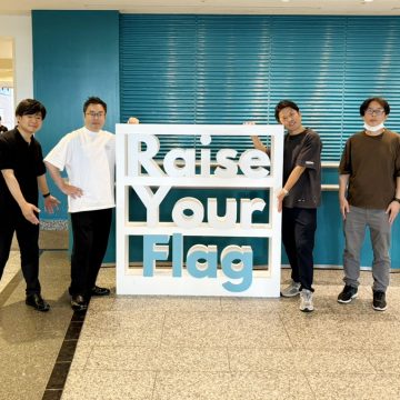 サマーコンファレンス会場入り口の看板前にて
